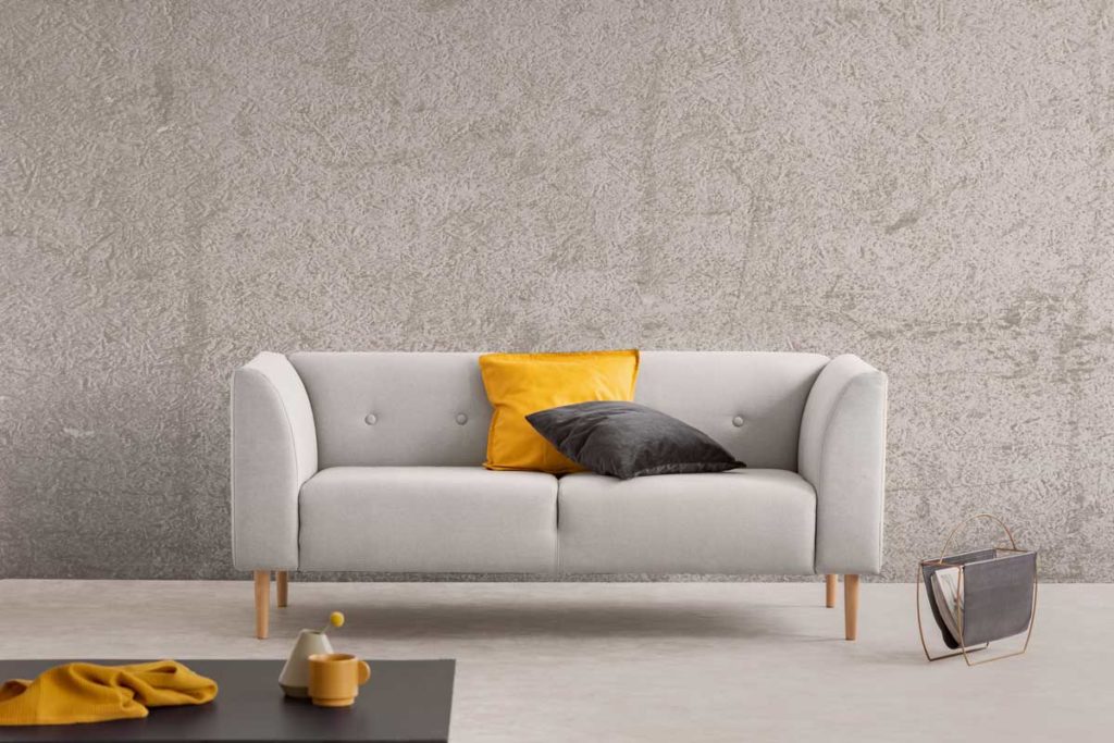 La simplicité incarnée dans un salon avec un canapé gris et un mur brut